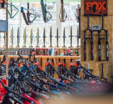 Fahrradladen voller Fahrräder, Ersatzteile und Zubehör an Regalen und Wänden.