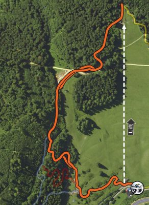 Karte mit orange markierten Weg im Wald, daneben beschrifteter Liftverlauf und ein Shop-Symbol.