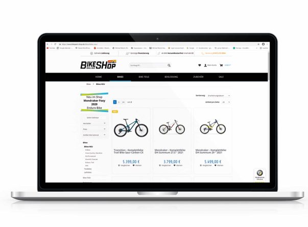 Laptop zeigt eine Website mit Fahrrädern zum Verkauf, Preise und Bilder von drei Modellen sind sichtbar.